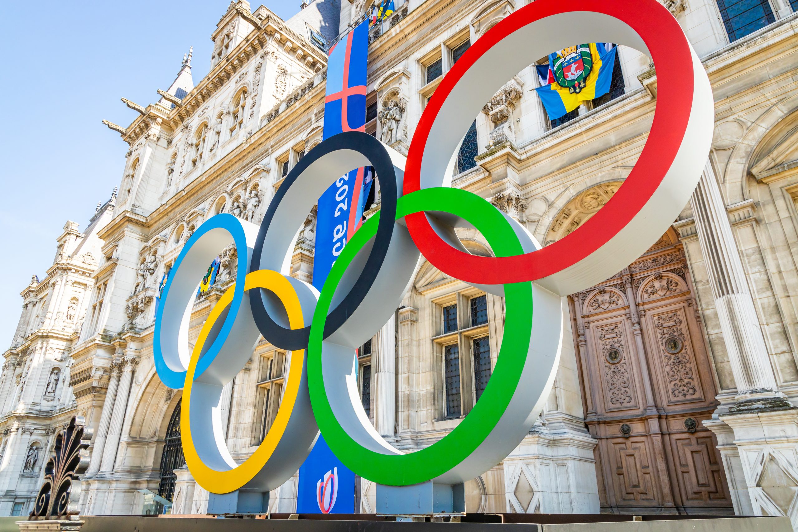 Olympic rings in front of building.